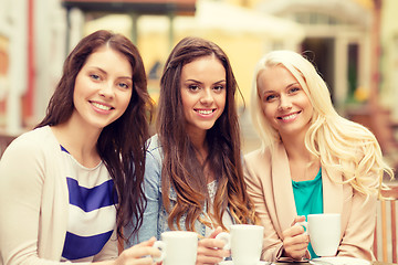 Image showing three beautiful girls drinking coffee in cafe