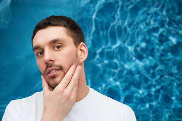 Image showing beautiful calm man touching his face