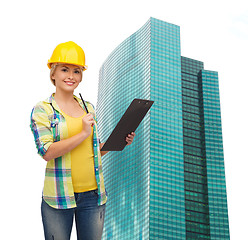 Image showing smiling woman in helmet with clipboard