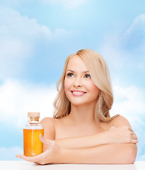 Image showing happy woman with oil bottle
