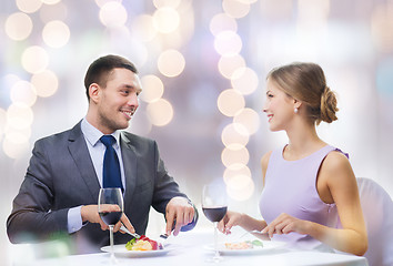 Image showing smiling couple eating main course at restaurant