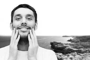 Image showing beautiful smiling man touching his face