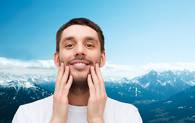 Image showing beautiful smiling man touching his face