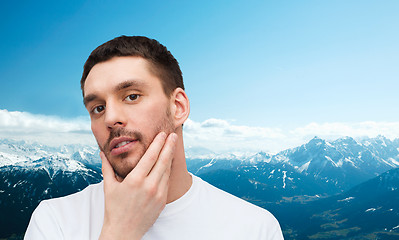 Image showing beautiful calm man touching his face