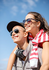 Image showing smiling teenagers in sunglasses having fun outside