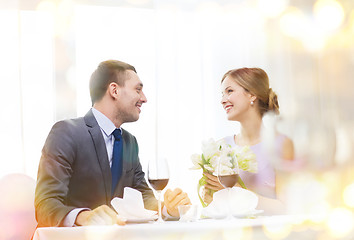 Image showing smiling man giving flower bouquet at restaurant