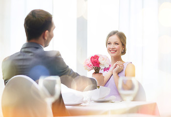 Image showing smiling woman recieving bouquet of flowers