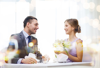 Image showing smiling man giving flower bouquet at restaurant