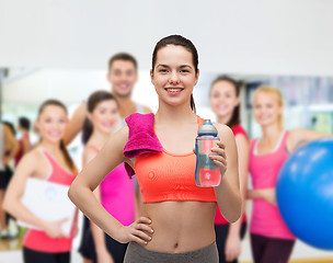 Image showing sporty woman with towel and water bottle