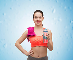 Image showing sporty woman with towel and water bottle