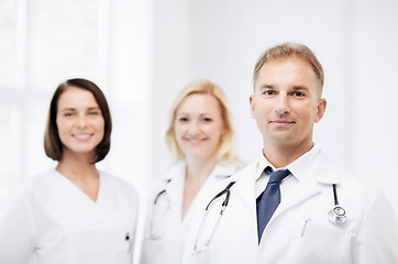 Image showing doctor with stethoscope and colleagues
