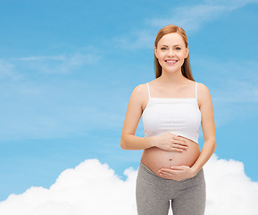 Image showing happy future mother touching her belly