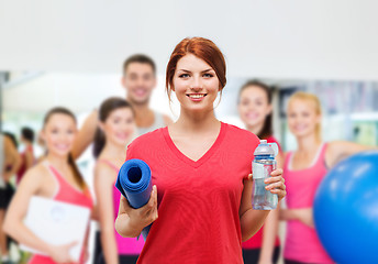 Image showing smiling girl with bottle of water after exercising