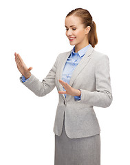 Image showing smiling businesswoman pointing to something