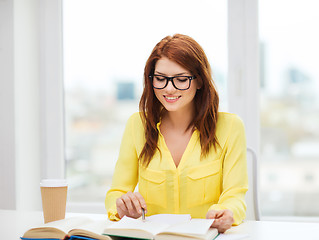 Image showing smiling student girl reading books in library