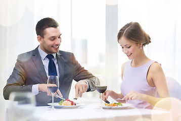 Image showing smiling couple eating main course at restaurant