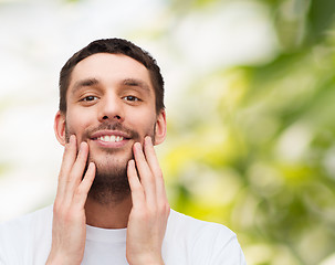 Image showing beautiful smiling man touching his face