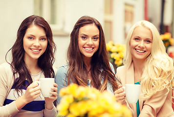 Image showing three beautiful girls drinking coffee in cafe