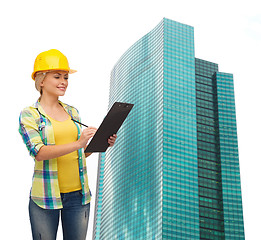 Image showing smiling woman in helmet with clipboard