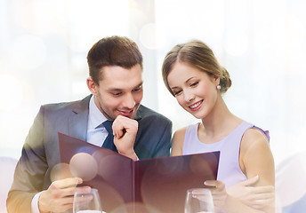 Image showing smiling couple with menu at restaurant