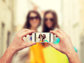 Image showing close up of hands taking picture with smartphone