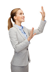 Image showing smiling businesswoman pointing to something