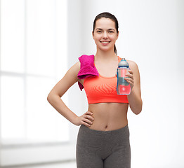 Image showing sporty woman with towel and water bottle