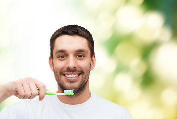 Image showing smiling young man with toothbrush