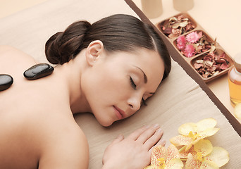 Image showing asian woman in spa with hot stones