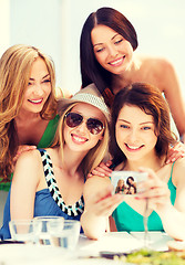 Image showing girls taking photo in cafe on the beach