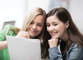 Image showing student girls pointing at notebook at school