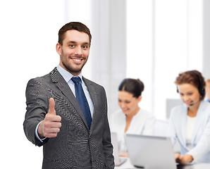 Image showing handsome buisnessman showing thumbs up in office