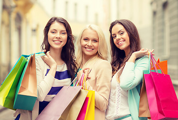 Image showing three smiling girls with shopping bags in ctiy
