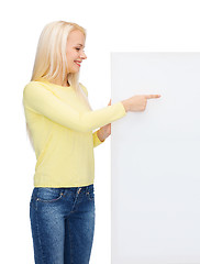 Image showing smiling woman in sweater with blank white board