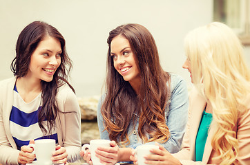 Image showing three beautiful girls drinking coffee in cafe