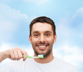 Image showing smiling young man with toothbrush