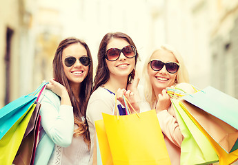 Image showing three smiling girls with shopping bags in city