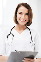 Image showing doctor with stethoscope writing prescription