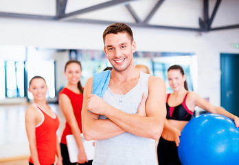 Image showing smiling man standing in front of the group in gym