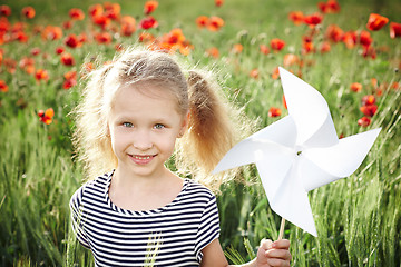 Image showing Happy laughing little girl  on the poppy meadow