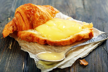 Image showing Croissant with cream and teaspoon.