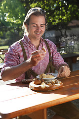 Image showing Attractive man eats traditional cheese in a Bavarian beer garden