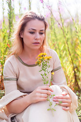 Image showing Beautiful sad girl sitting on meadow