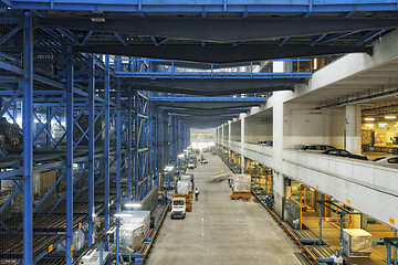 Image showing Rows of shelves with boxes in factory warehouse 