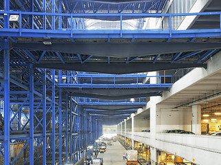 Image showing Rows of shelves with boxes in factory warehouse 