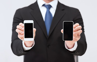 Image showing businessman showing smartphones with blank screens