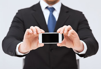 Image showing businessman showing smartphone with blank screen