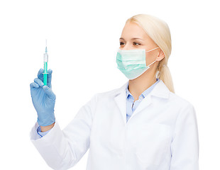 Image showing doctor in mask holding syringe with injection