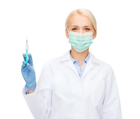 Image showing doctor in mask holding syringe with injection