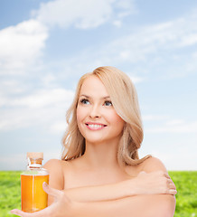 Image showing happy woman with oil bottle